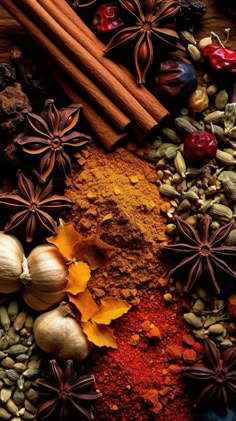 an assortment of spices and herbs on a wooden surface with cinnamons, cloves, star anise, pepper