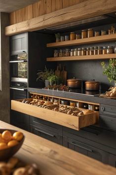 a kitchen filled with lots of counter top space next to a wooden table topped with food