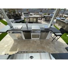 an outdoor kitchen with stainless steel appliances and bar stools is seen from the air