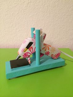 a desk with a pen and paper holder on top of green table next to white wall