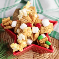 a red bowl filled with cheetos and marshmallows on top of a table