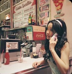 a woman sitting at a counter talking on a cell phone