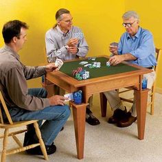 three men sitting at a table playing cards