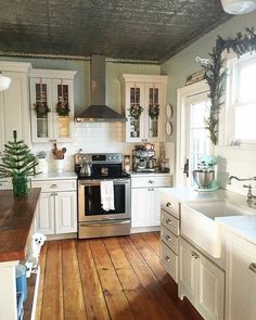 a kitchen with white cabinets and wood floors is seen in this image, while the light shines on the stove