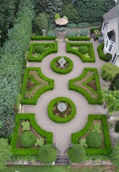 an aerial view of a formal garden in the middle of a home's yard