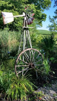 an old spinning wheel in the middle of a garden