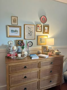 a dresser with many pictures on the wall