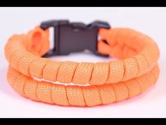 two orange bracelets with black clasps on white background