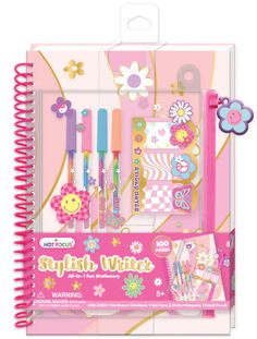 a pink notebook with pens and flowers on it