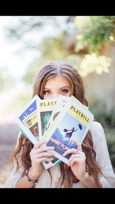 a woman holding up four books in front of her face