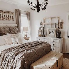 a bedroom with a bed, dresser and mirror on the wall next to a window