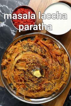 masala lacecha paratha in a metal bowl next to a glass of milk