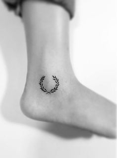 a woman's foot with a small tattoo on it