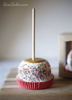 a cupcake covered in sprinkles with a candle sticking out of it