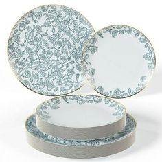 four plates stacked on top of each other with blue and white designs in the middle