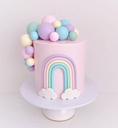 there is a pink cake with a rainbow on it