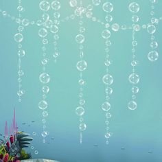 bubbles floating in the air over a table with flowers and plants on top of it