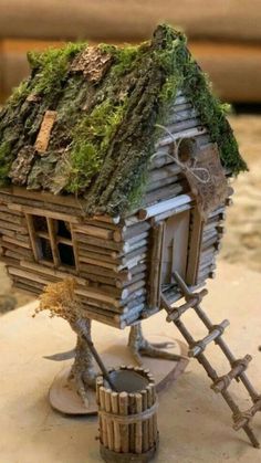 a miniature house made out of wood and moss