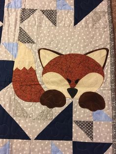 a close up of a quilt with a fox on it