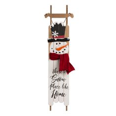 a wooden snowman with a red scarf and hat on it's head hanging from a