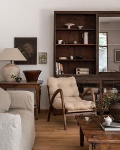 a living room filled with furniture and a wooden coffee table in front of a mirror