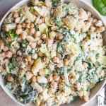 a salad with broccoli, chickpeas and spinach in a white bowl