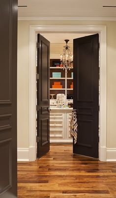 an open door leading to another room with wooden floors and white walls in the background