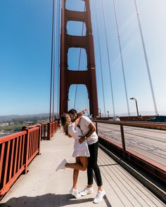 a man and woman kissing on the golden gate bridge