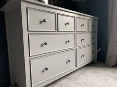 a white dresser with drawers in a room