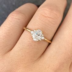 a woman's hand with a diamond ring on top of her finger, showing the center stone