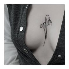 a woman's chest with a tattoo on it that has flowers growing out of it