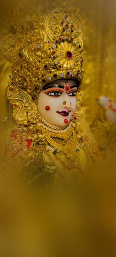 a close up of a mask with gold and red decorations on it's face