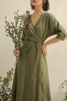 It may be hot outside, but you’ll barely notice in our wrap dress. Made of soft, imported linen to keep you cool, you’ll be too busy soaking in the compliments to notice the heat. Our wrap dress lands below the knee for a universally flattering fit, and has short sleeves and a matching tie belt to ensure the best fit possible. With a v-neck and a-line skirt, you’ll be cool and chic all in one wearing our wrap dress. Green Linen Wrap Dress, Sage Green Linen Dress, Wrap Dress Linen, A Line Casual Dress, Soft Summer Romantic, Earth Tone Aesthetic Fashion, Simple Casual Dresses, Minimal Casual Outfit, Wrap Around Dresses