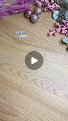 a wooden table topped with lots of purple flowers and plants on top of it's surface