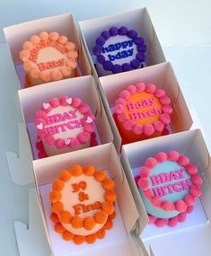 six decorated birthday cakes in boxes on a table