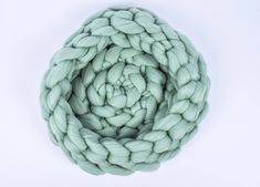 a large green yarn ball on a white surface with the center knoted in to it's center