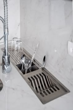 a kitchen sink filled with silverware and utensils