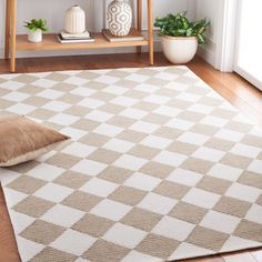 a beige and white rug with a pillow on the floor in front of a shelf