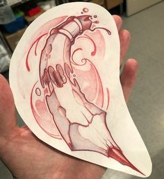 a hand holding a piece of paper with a drawing on it