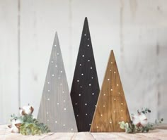 three wooden christmas trees sitting on top of a table