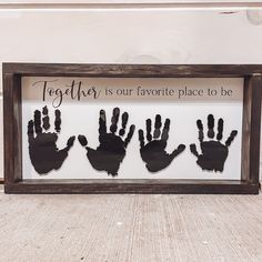 three handprints in a shadow frame that says together is our favorite place to be