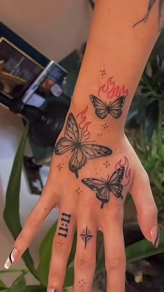 a woman's hand with three butterflies on it and the word love written in cursive writing