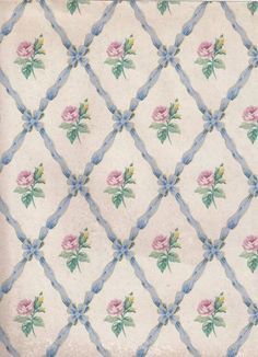 an old quilt with pink roses on it and blue ribbon around the edges that are stitched together