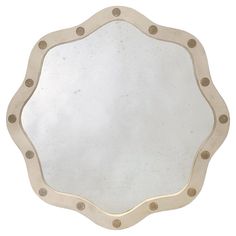 a mirror that is sitting on top of a white surface with rivets around it