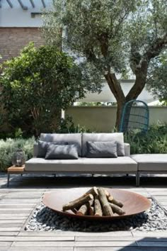 a couch sitting on top of a wooden floor next to a fire pit