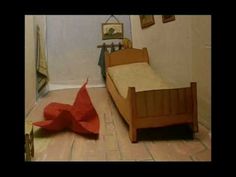 an image of a bedroom setting with a bed and red origami paper on the floor