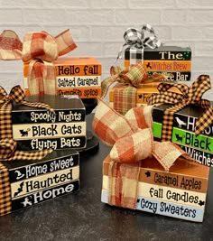 four wooden boxes decorated with plaid bows and sayings are sitting on a black table