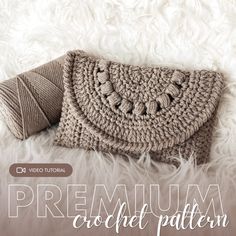 a crocheted purse sitting on top of a fluffy white blanket