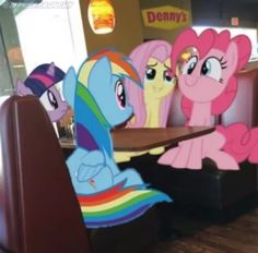 there are many little ponys sitting at the table in front of this restaurant booth