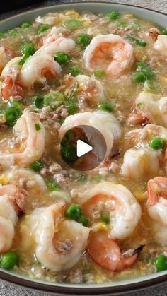 a bowl filled with shrimp and peas on top of a table